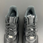 Pair of dark lace-up sneakers with perforated toe and padded collar