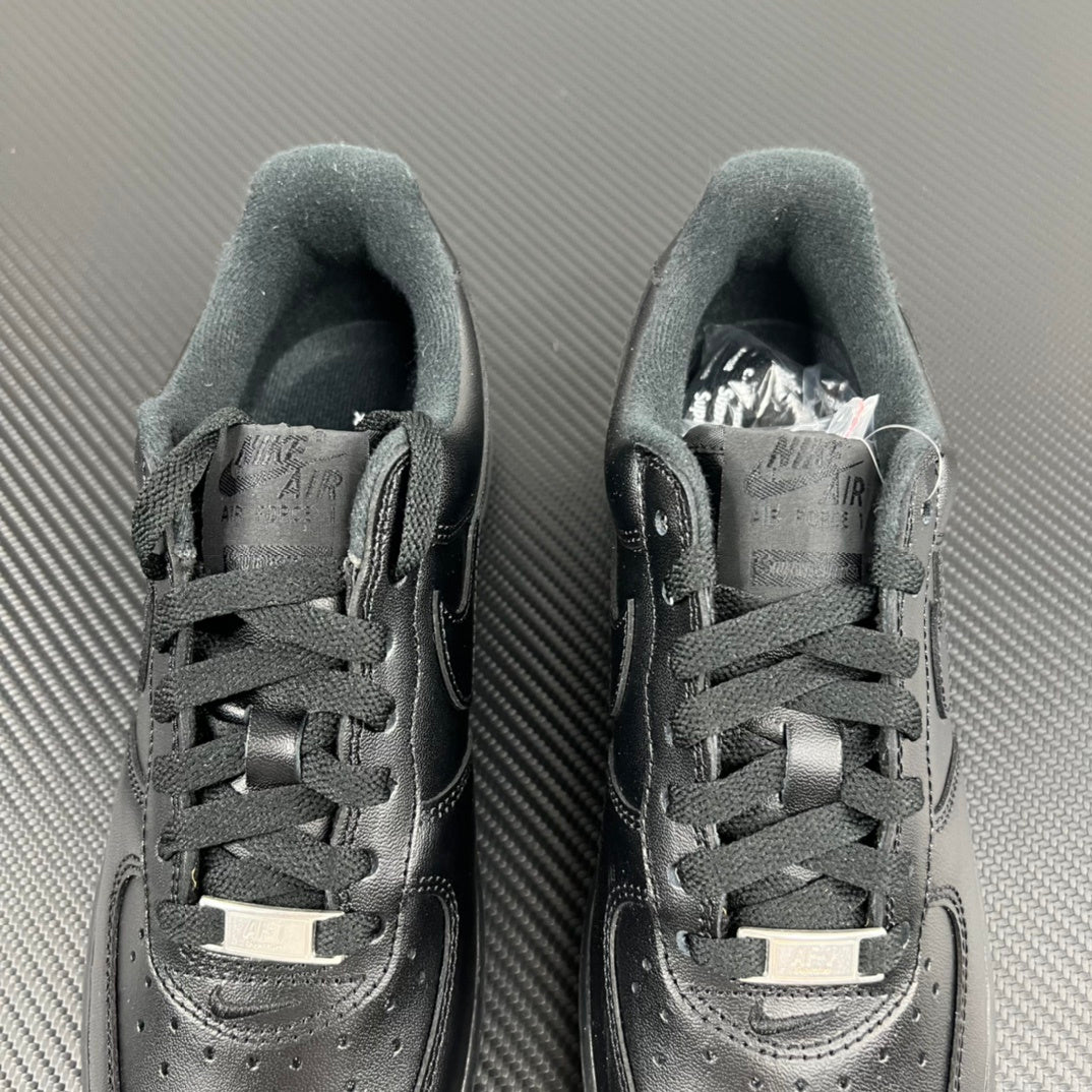 Pair of dark lace-up sneakers with perforated toe and padded collar