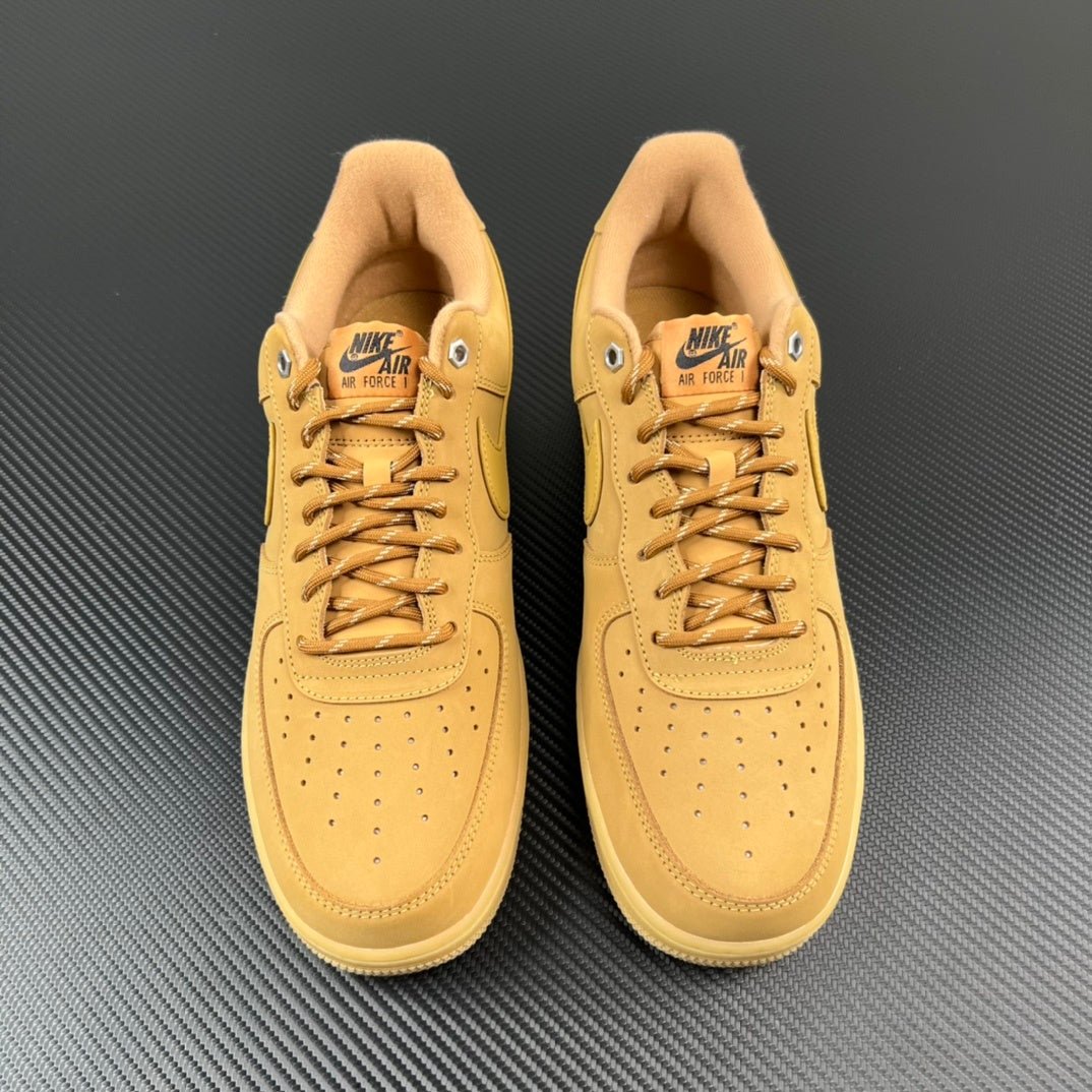Pair of tan/yellow lace-up sneakers with perforations and Nike Air logo