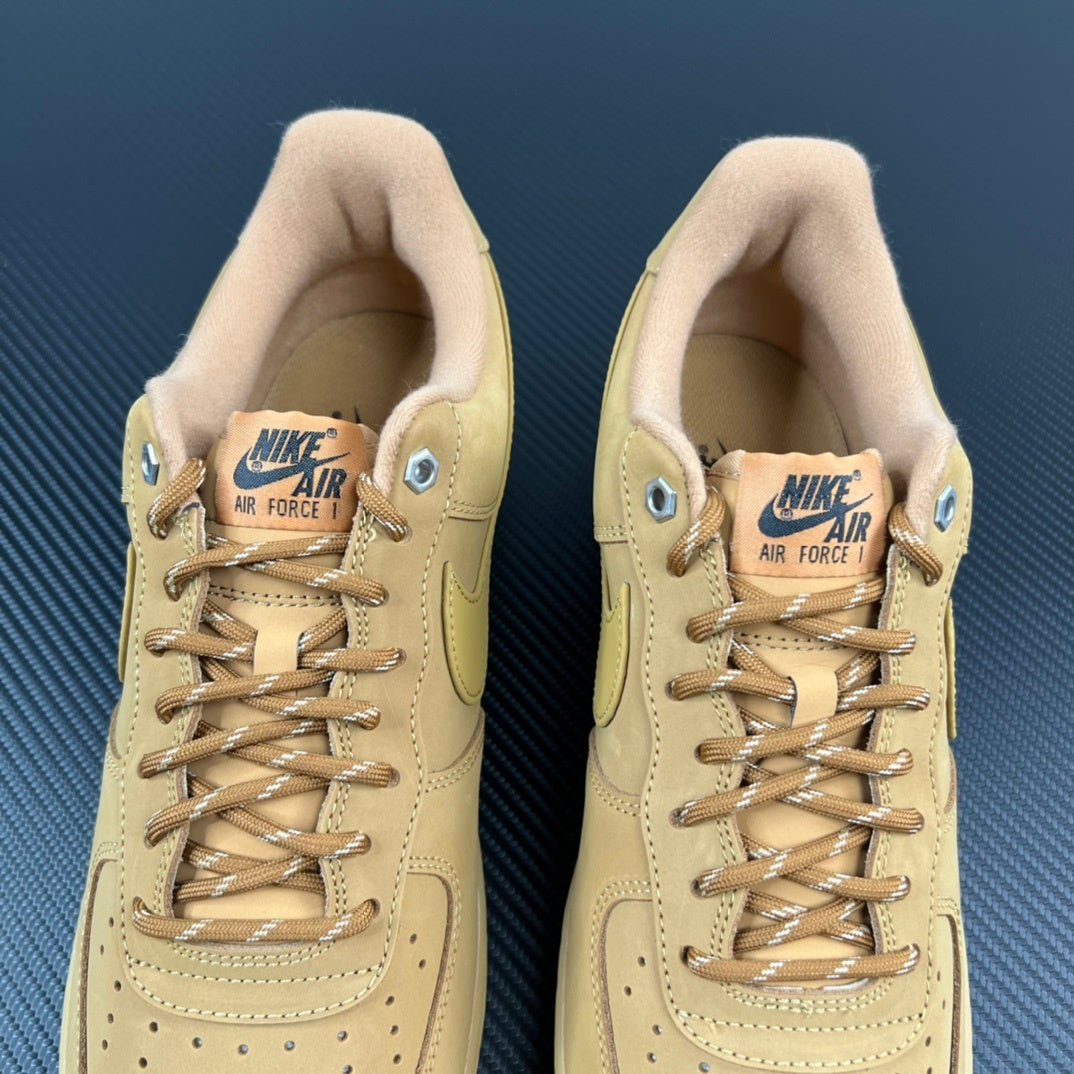Two tan/yellow suede sneakers with lace-up fronts and padded collars