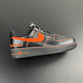 Black and silver Air Force 1 sneaker with orange swoosh and contrast stitching