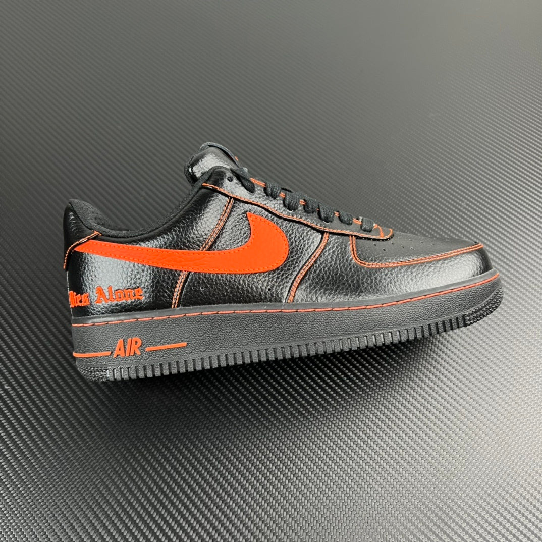 Black and silver Air Force 1 sneaker with orange swoosh and contrast stitching