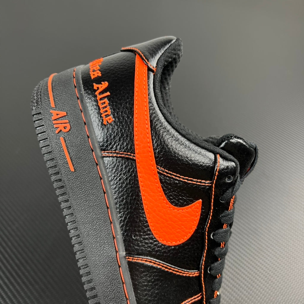 Black and silver Air Force 1 sneaker with orange heel stripe and side label