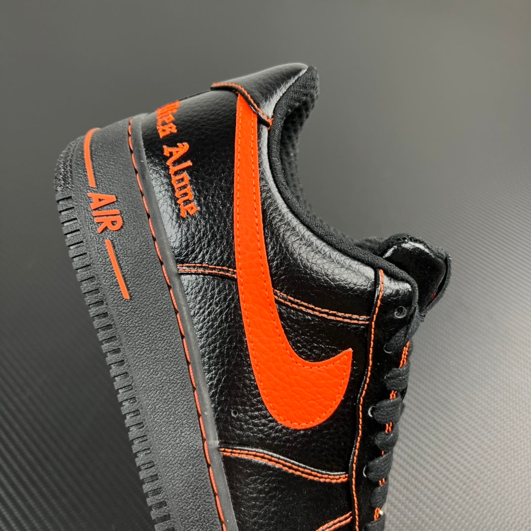 Black and silver Air Force 1 sneaker with orange heel stripe and side label