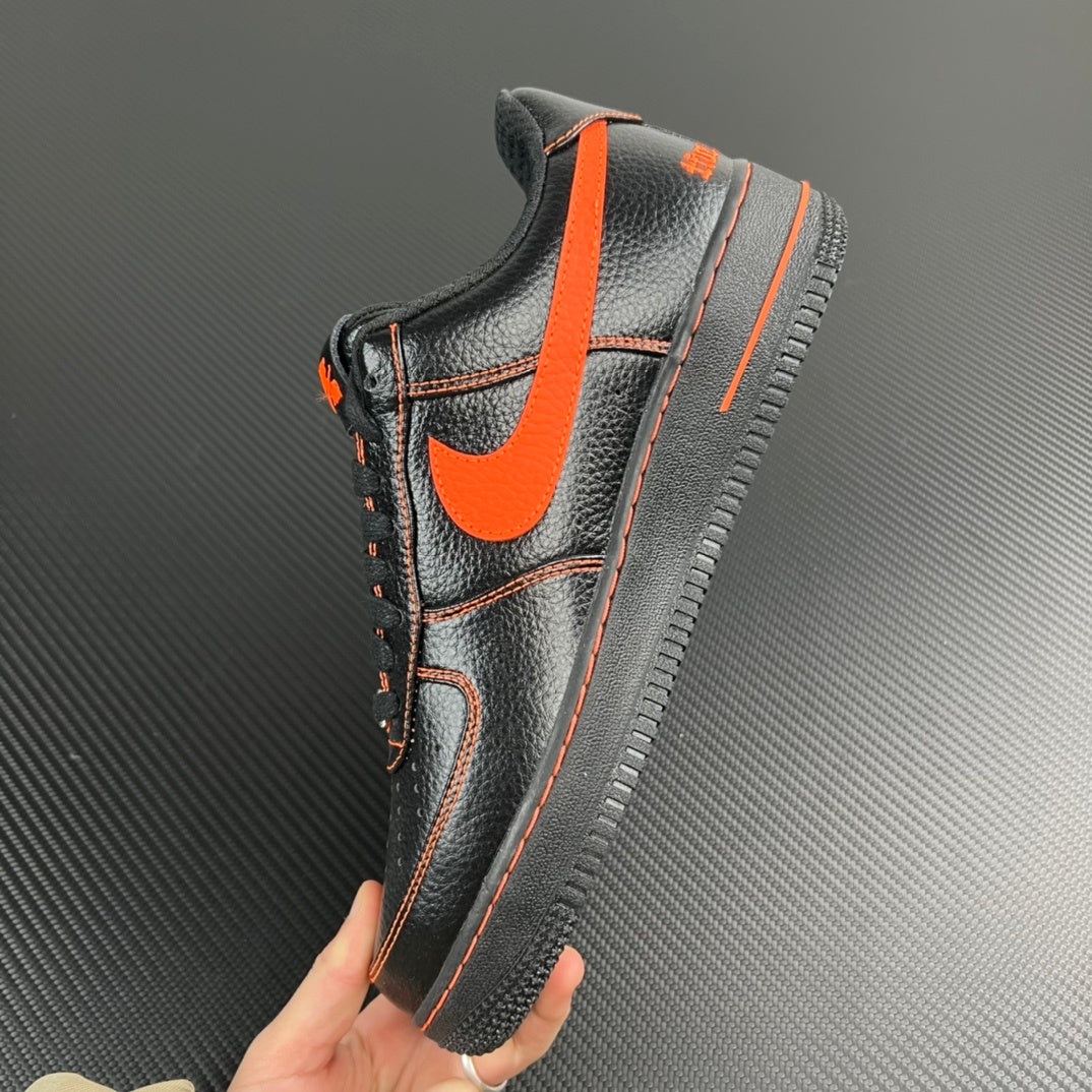 Black and silver Air Force 1 sneaker with orange swoosh and orange-trim collar