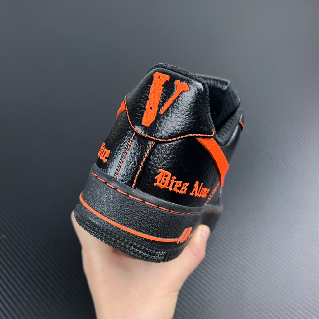 Black Air Force 1 high-top sneaker with orange stripe and heel lettering patch