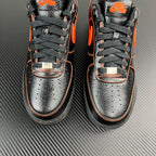 Close front view of black and silver Air Force 1 sneakers with orange swoosh