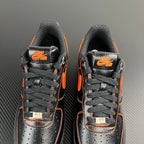 Front view of black and silver Air Force 1 sneakers with orange accents and AF1 tags
