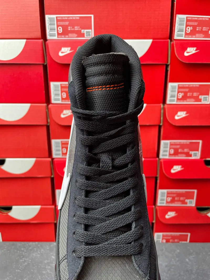 Black Nike high-top sneaker heel and laces, back view against stacked boxes