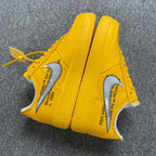 Yellow Air Force 1 sneakers with text print on sides and white swooshes