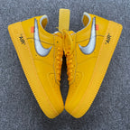 Pair of yellow Air Force 1 sneakers with white swooshes and lace-up fronts