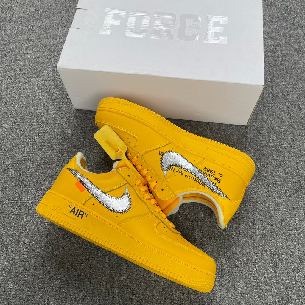 Yellow Air Force 1 sneakers with white swoosh and 'AIR' detail, beside white box