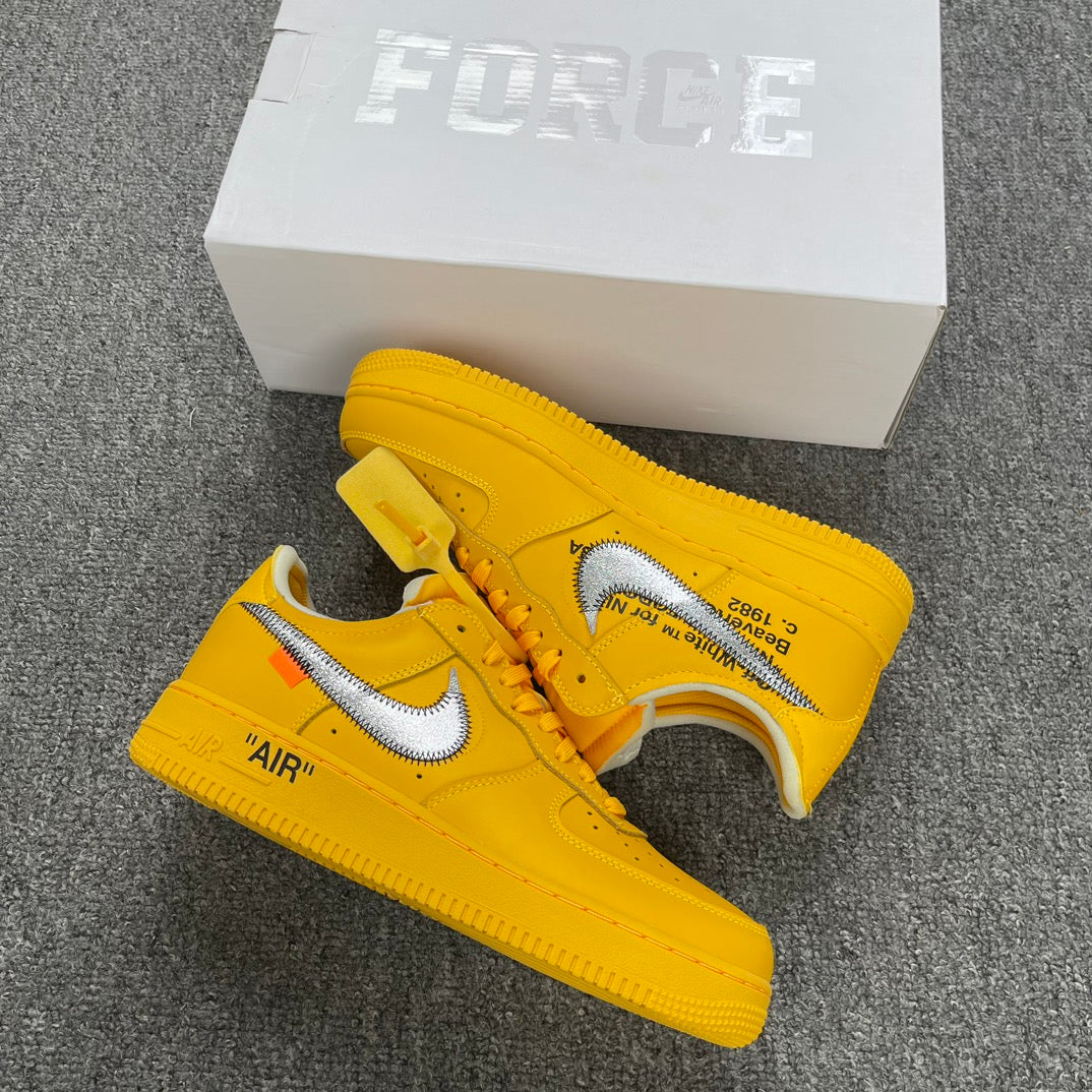 Yellow Air Force 1 sneakers with white swoosh and 'AIR' detail, beside white box