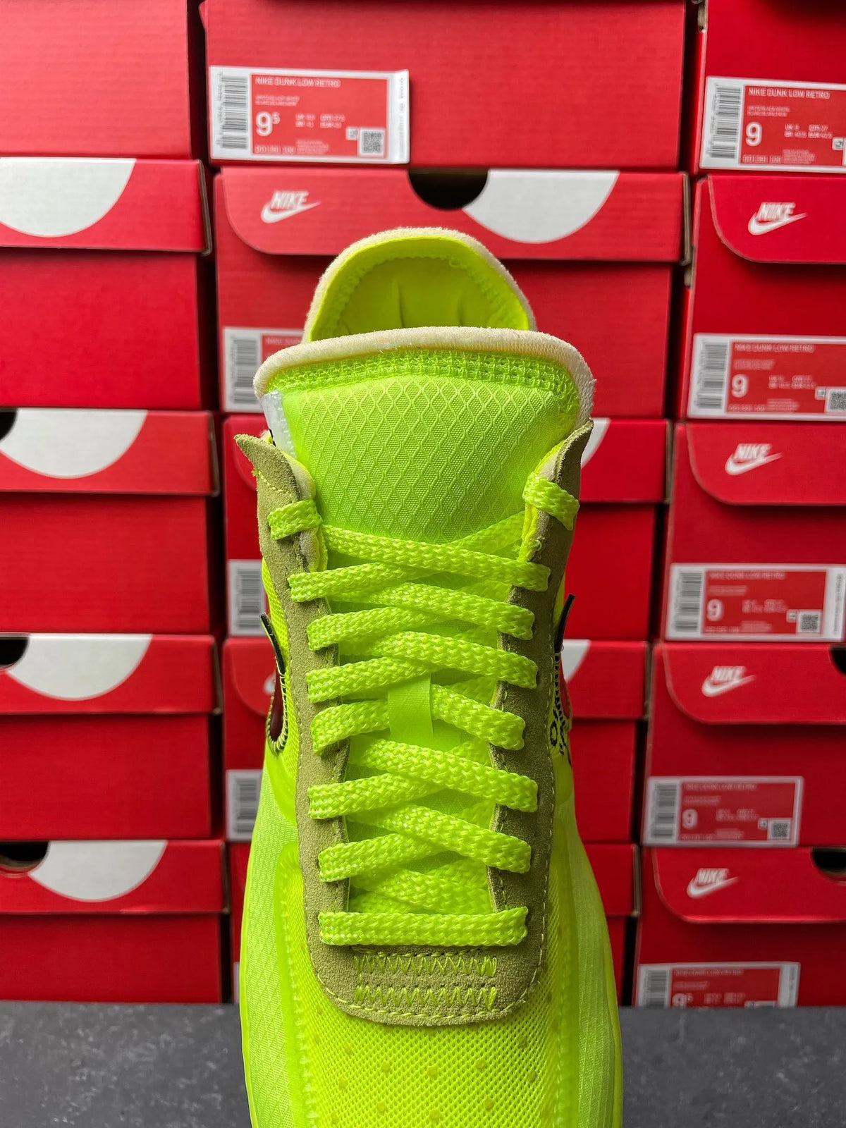 Neon green sneaker front view with padded collar and lace-up closure