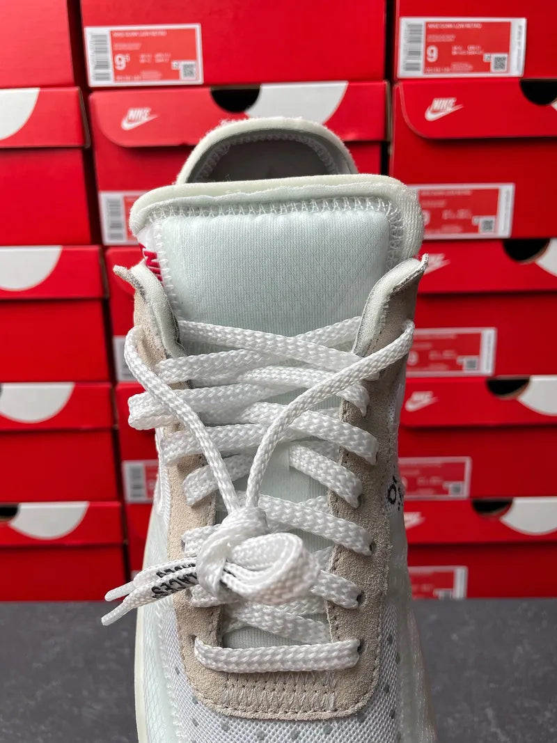 Off-white sneaker with white laces, padded tongue, and Nike sockliner