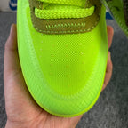 Neon green sneaker with textured sole and brown heel tab