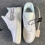 White low-top sneaker with side label text and gum-toned sole detail