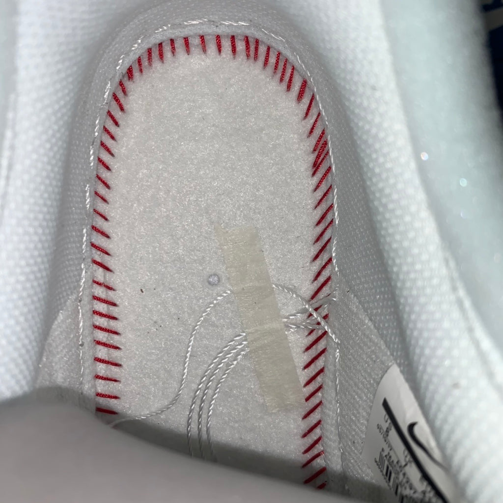 White sneaker interior lining with red-stitched seam details near the heel