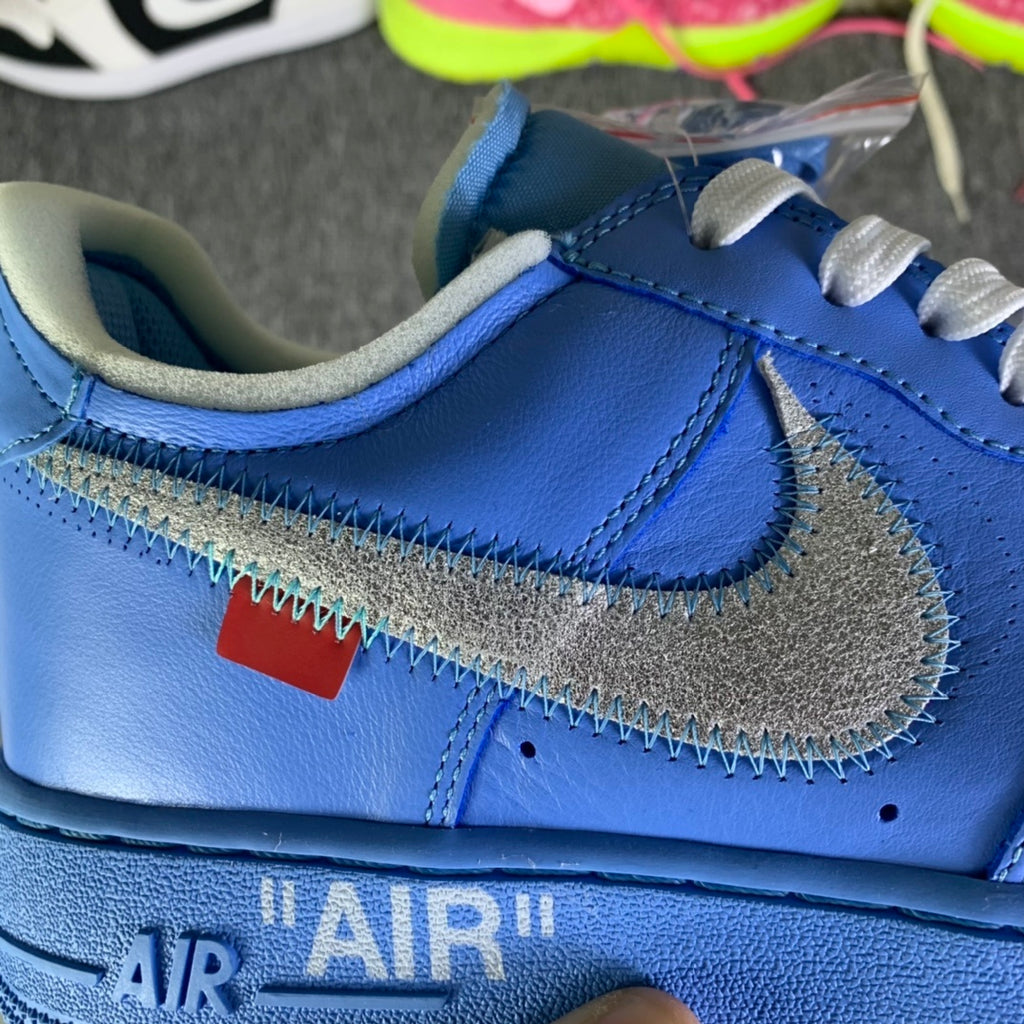 Blue low-top sneaker side view with stitched swoosh and AIR midsole text