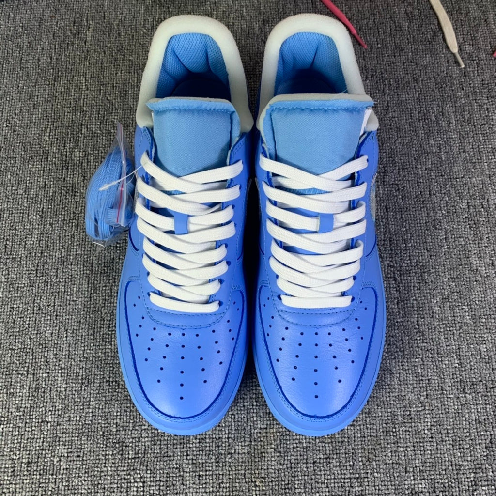 Blue low-top sneakers front view with white laces and perforated toe