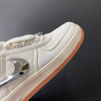 Low-top sneaker side panel in sail with chrome swoosh and orange gum sole