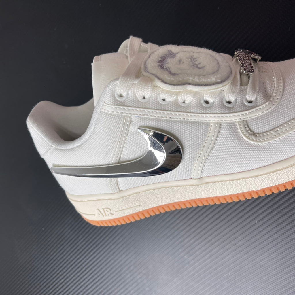 Low-top sneaker with sail upper, chrome heel logo, and orange gum sole