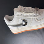 Low-top sneaker with sail upper, chrome heel logo, and orange gum sole