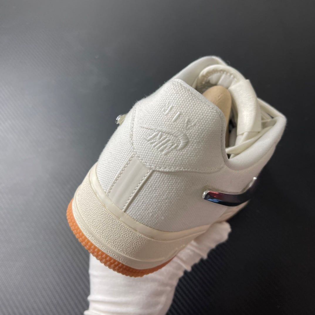 Low-top sneaker with sail heel patch, lace-up collar, and orange gum sole