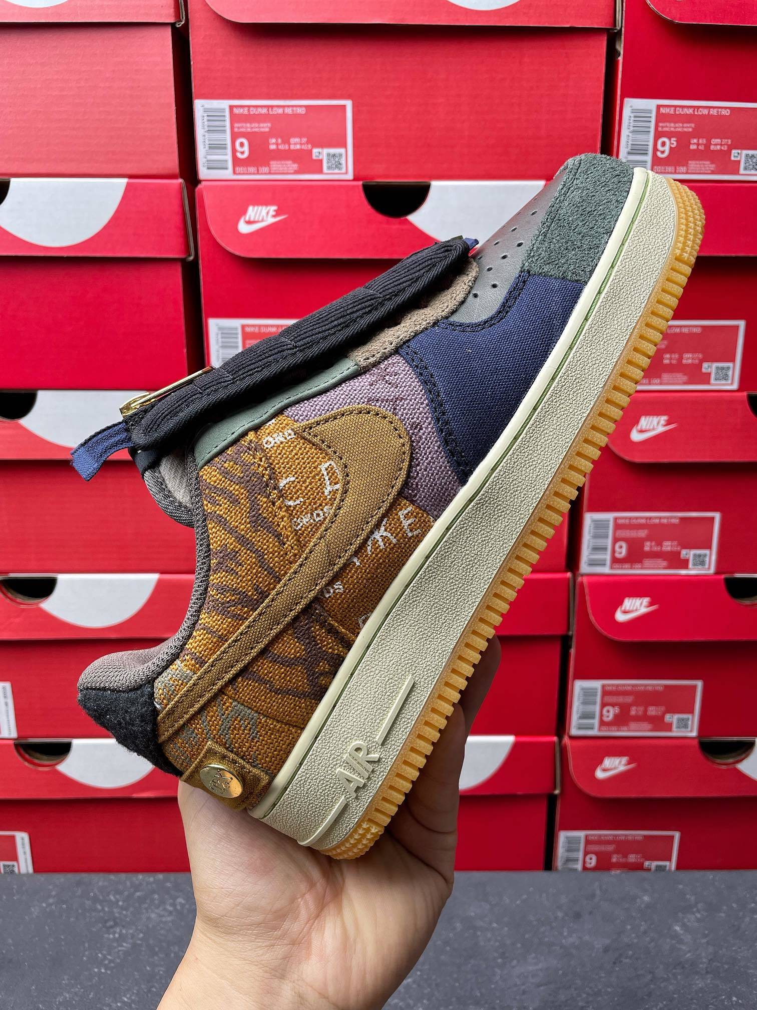Low-top sneaker side view with olive suede, yellow logo patch, and dark laces