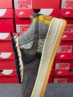 Low-top sneaker with green mesh upper, black swoosh, and tan outsole edge