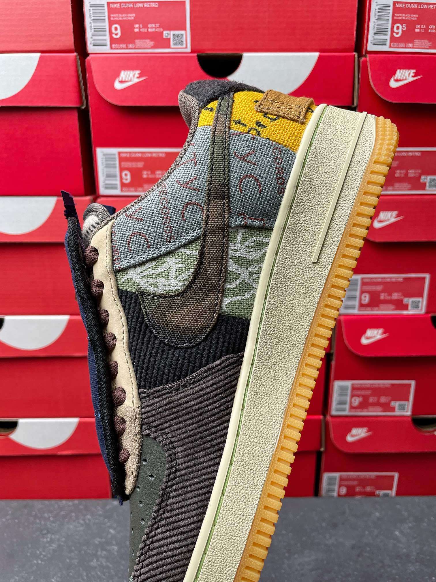 Low-top sneaker with green mesh upper, black swoosh, and tan outsole edge