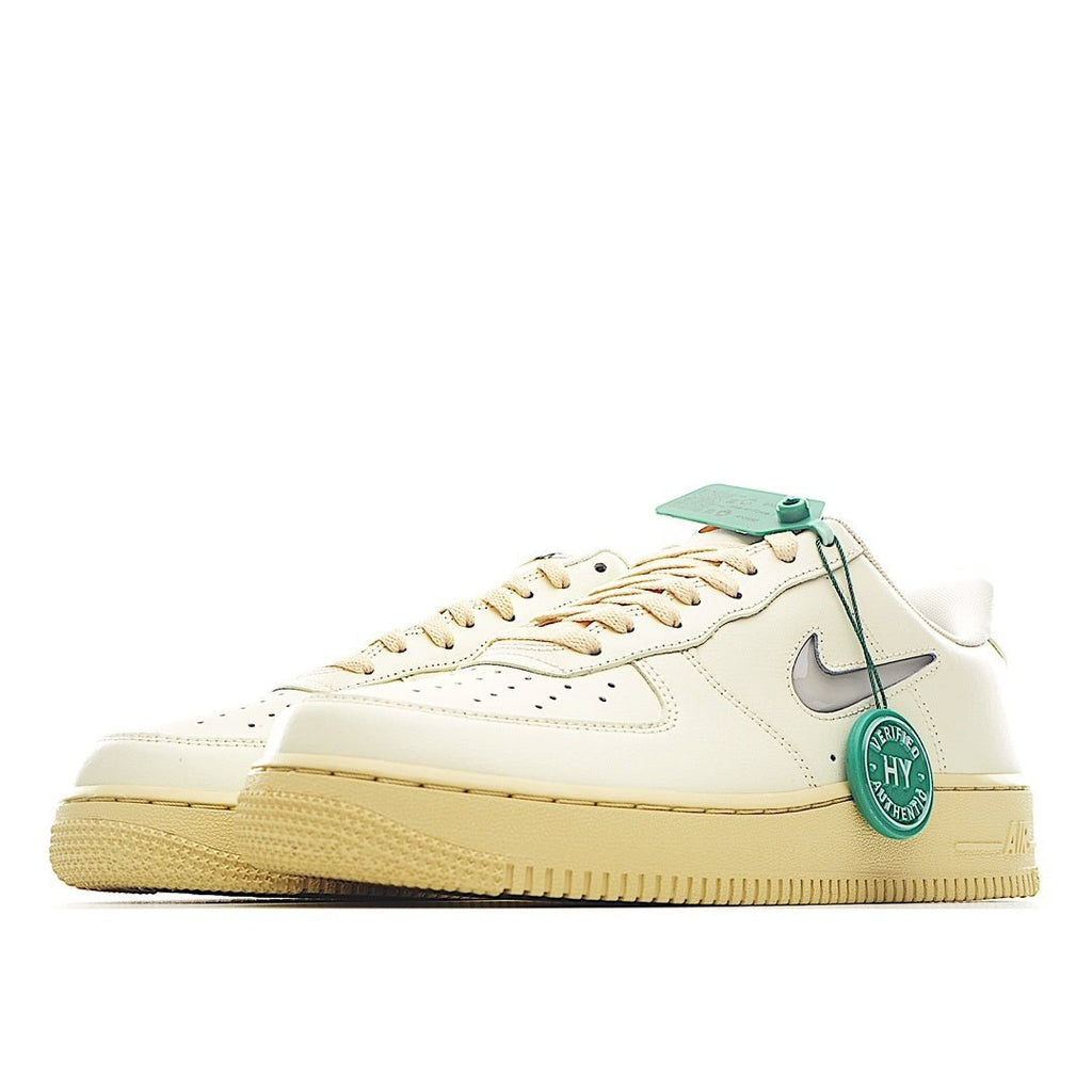 Nike Air Force 1 sneaker side view in light cream with green tag and gum outsole