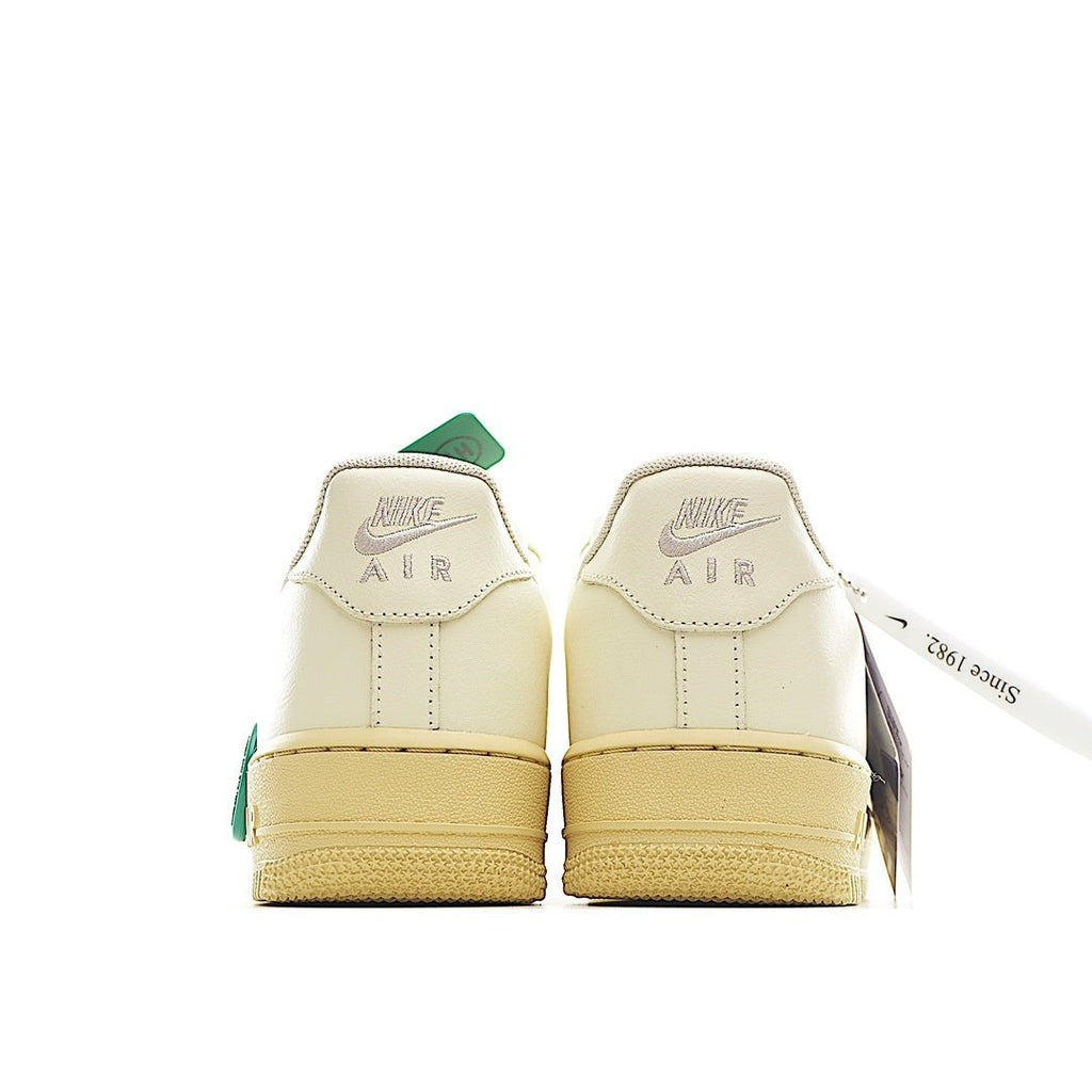 Nike Air Force 1 sneaker heel view in light cream with green pull tab