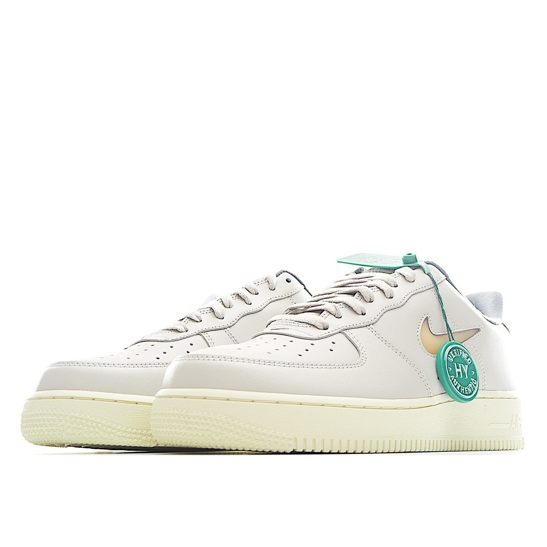 White low-top Nike Air Force 1 sneakers, side profile with gold logo and green tags