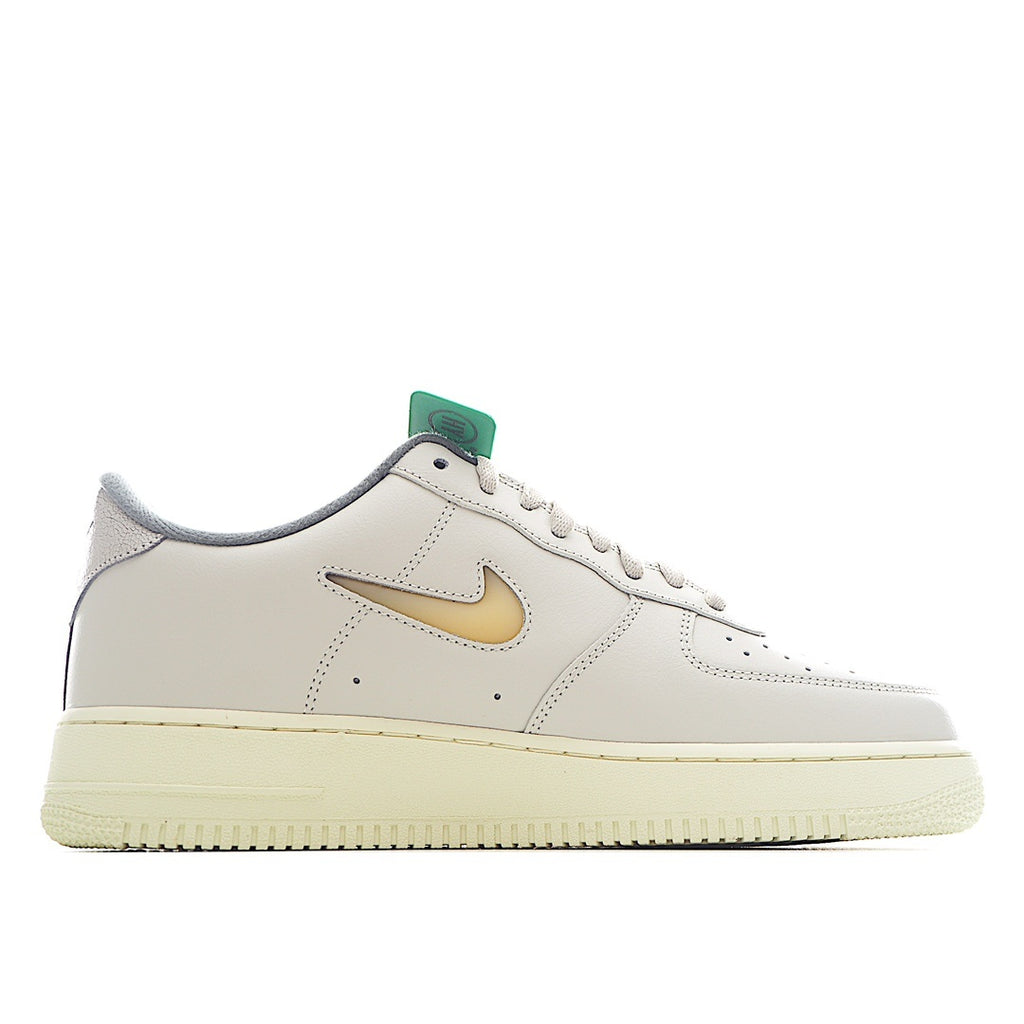 White Nike Air Force 1 sneakers with tan/gold swoosh and green lace loop
