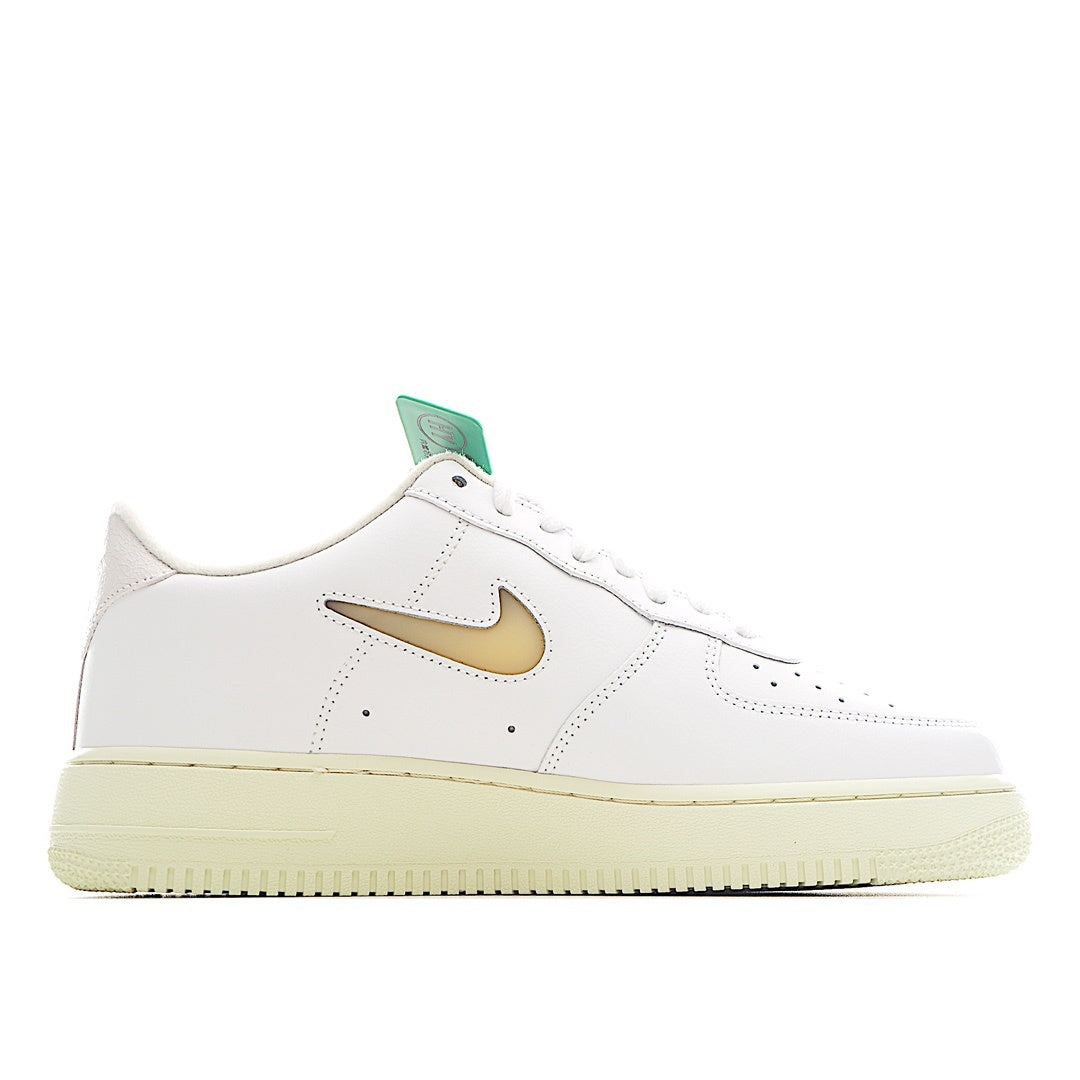 White leather low-top sneaker with gold swoosh, perforated toe, and green lace tag