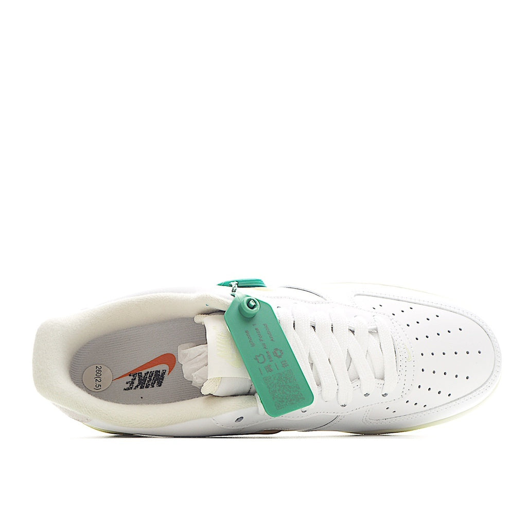 White low-top sneaker with white laces and green heel pull tab