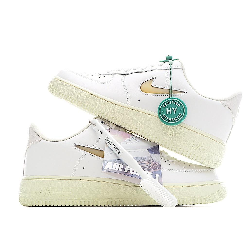 White leather low-top sneaker with gold swoosh, green lace tag, and tan gum sole