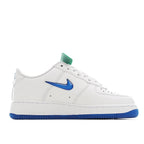 White Nike Air Force 1 low-top sneaker with blue swoosh and teal tag