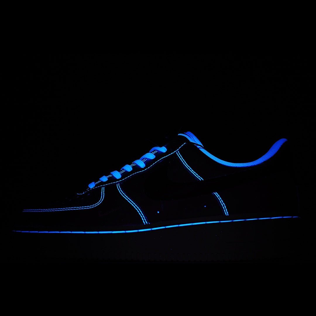 Dark sneaker with bright blue neon trim and blue laces on dark upper