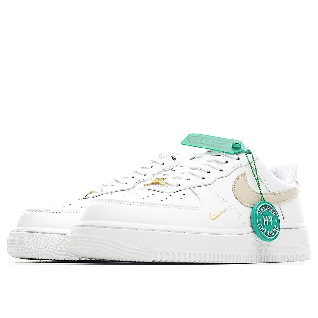 Nike Air Force 1 sneaker, white upper with beige swoosh and gold detail, green tag