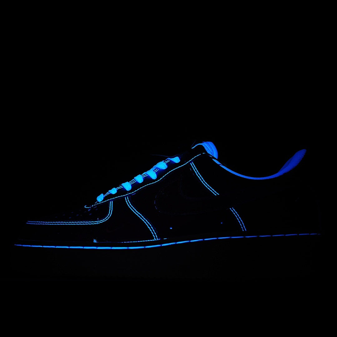 Low-top sneaker with blue glow accents and neon-blue laces on dark