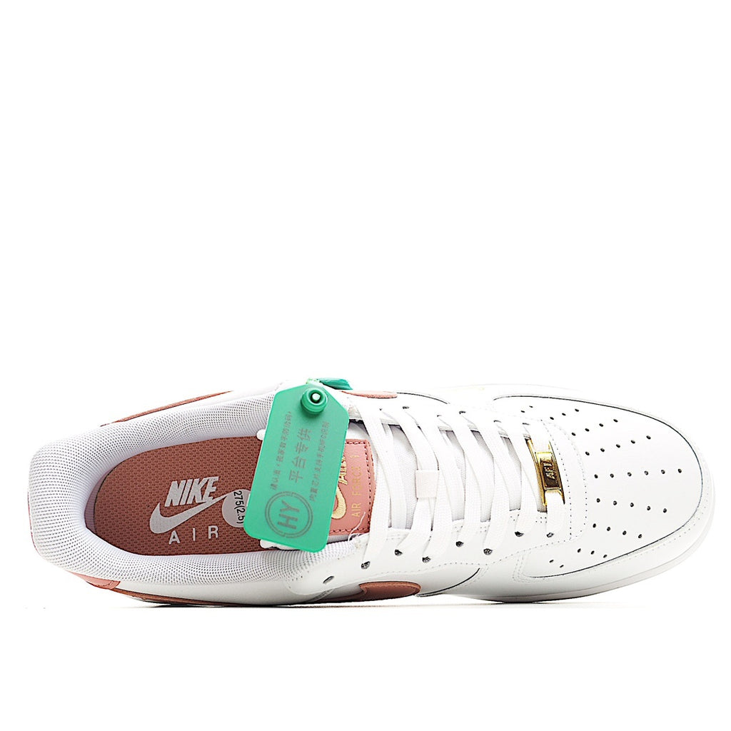 Nike Air Force 1 sneakers, white upper with pink lining and green tag at tongue