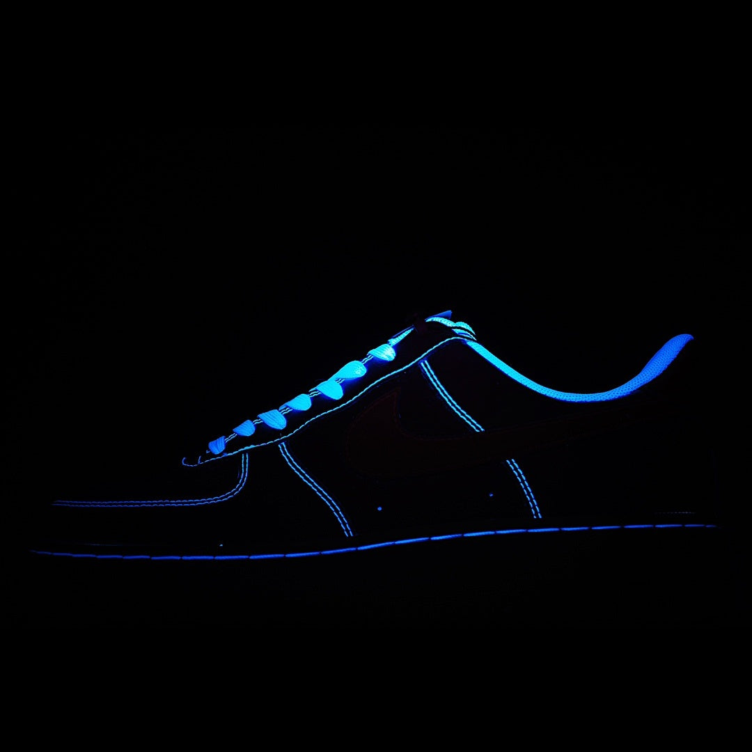 Nike Air Force 1 sneakers with dark upper and bright blue glowing lace and trim