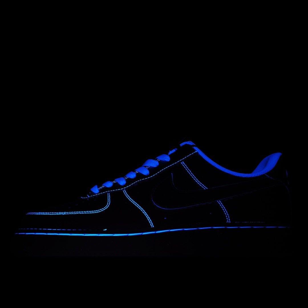 Dark blue low-top sneaker with neon-blue outline on a dark background