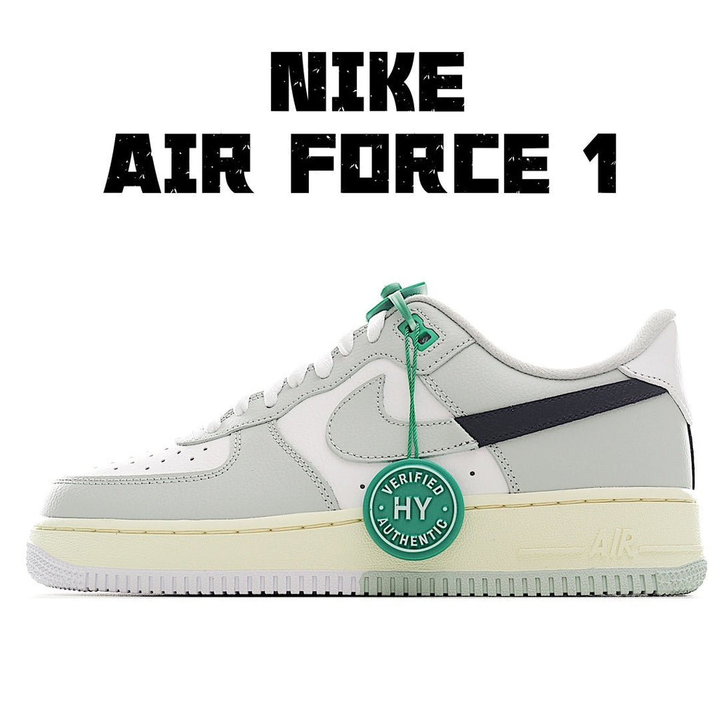 White Air Force 1 sneaker with navy side panel, green lace tag, and light gum midsole.