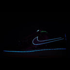 Dark sneakers with glowing blue Nike swoosh and outline on a black background