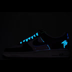 Dark Nike Air Force 1 sneakers with blue glowing lace and swoosh accents