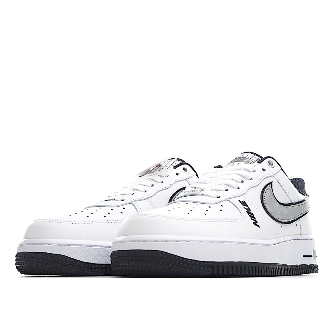 White low-top sneaker pair, front view with black Swoosh and navy heel tab.