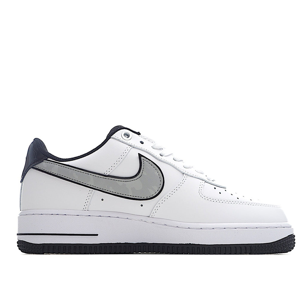 White low-top sneaker with navy heel and black Swoosh, side profile.